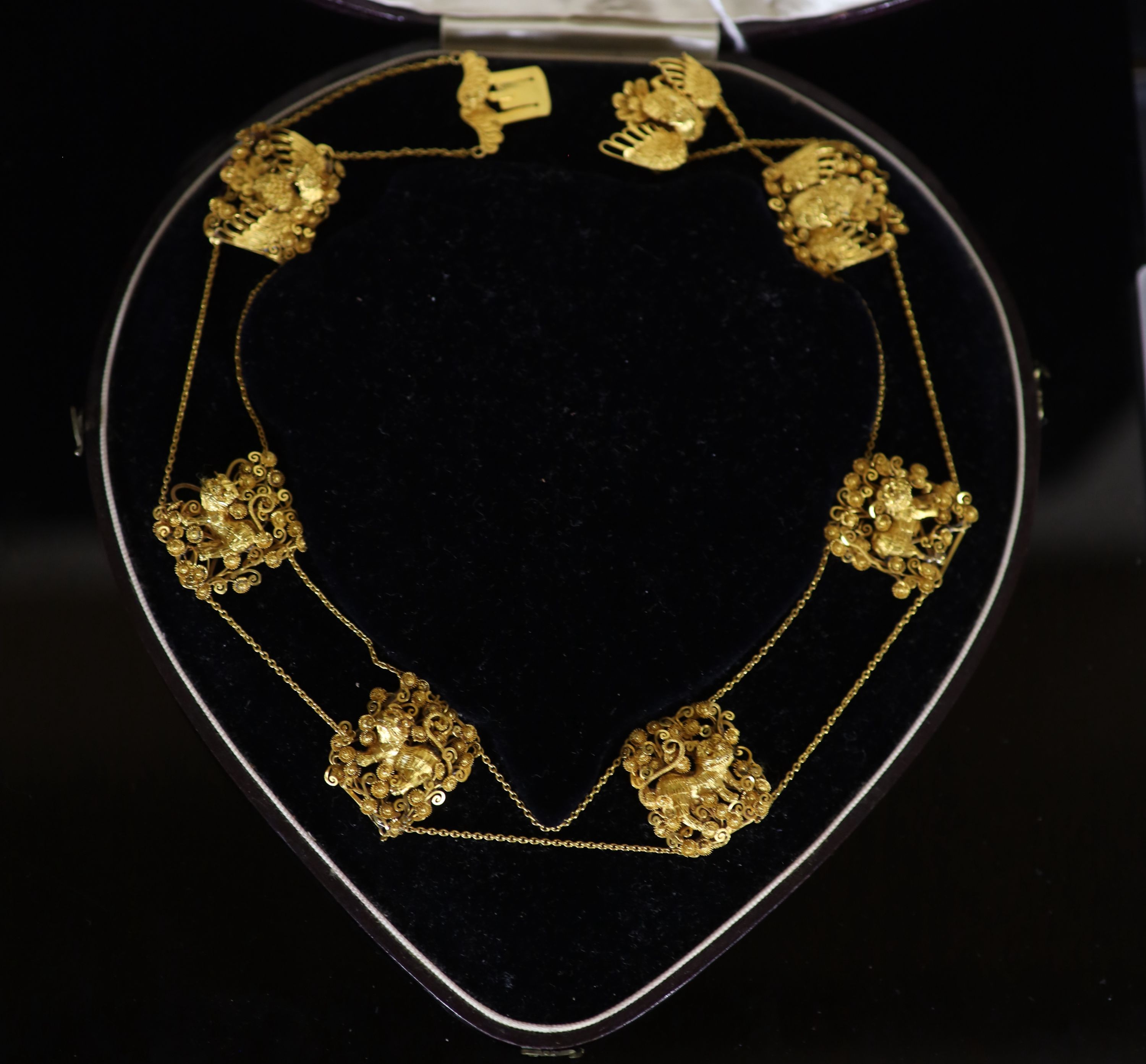 An early 20th century Chinese filigree gold (stamped 20) twin strand necklace with six pierced panels and clasp decorate with Buddhist lions and Phoenixes